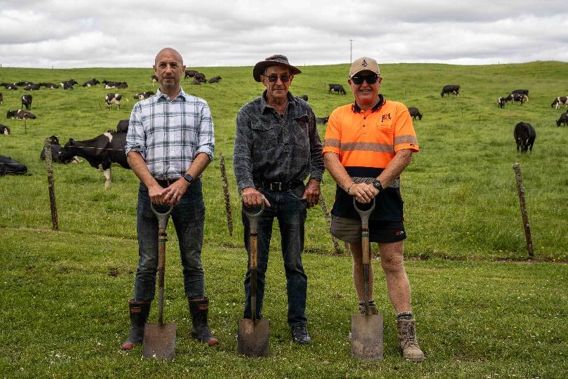 A group of men holding shovels in a field